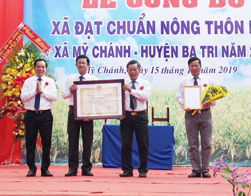 Phó bí thư Thường trực Tỉnh ủy Trần Ngọc Tam trao bằng công nhận xã Mỹ Chánh (Ba Tri) đạt chuẩn nông thôn mới. Ảnh: Quốc Hùng