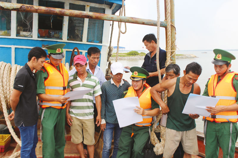 Cán bộ, chiến sĩ Trạm Kiểm soát biên phòng Bình Thắng tuyên truyền pháp luật về biển, đảo cho ngư dân. Ảnh: Ð. Chính