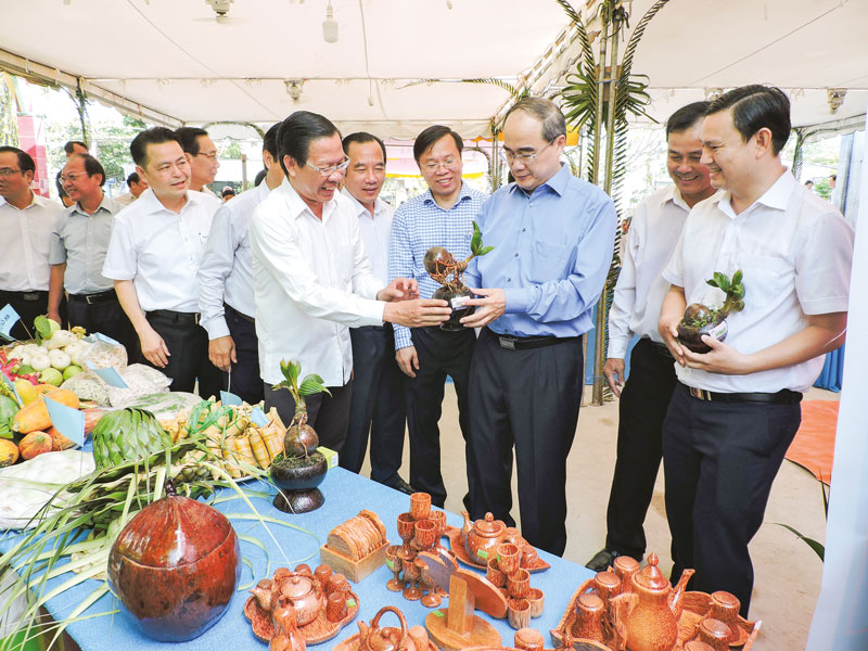 Bí thư Thành ủy TP. Hồ Chí Minh Nguyễn Thiện Nhân, Bí thư Tỉnh ủy Phan Văn Mãi tham quan gian hàng trưng bày sản phẩm làm từ dừa tại ấp Phú Mỹ, xã Phú Túc.