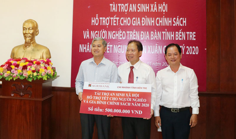 Ông Vũ Hồng Dụ (giữa) - Giám đốc Agribank Bến Tre trao biển tượng trưng số tiền tài trợ 500 triệu đồng cho UBND tỉnh.