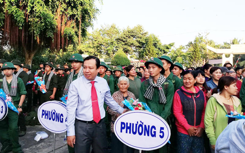 Chủ tịch UBND thành phố tặng hoa cho tân binh. Ảnh: Tô Vũ