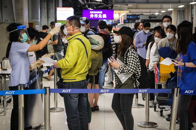 Nhân viên y tế kiểm tra thân nhiệt hành khách tại sân bay quốc tế Suvarnabhumi ở Bangkok, Thái Lan ngày 9-3-2020. Ảnh: AFP/TTXVN