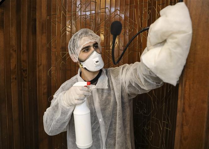 Công nhân phun thuốc khử trùng một nhà thờ nhằm ngăn dịch COVID-19 tại thành phố Hebron, Bờ Tây ngày 8-3-2020. Ảnh: AFP/TTXVN
