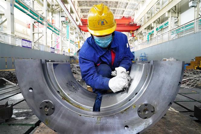 Do ảnh hưởng của dịch COVID-19, sản lượng công nghiệp Trung Quốc giảm lần đầu tiên trong 30 năm. Trong ảnh: Công nhân làm việc trong một nhà máy ở Cáp Nhĩ Tân ngày 9-3-2020. Ảnh: THX/TTXVN