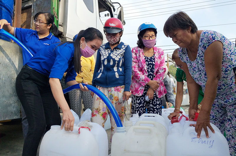 Đoàn viên, thanh niên hỗ trợ người dân lấy nước. Ảnh: Thanh Đồng