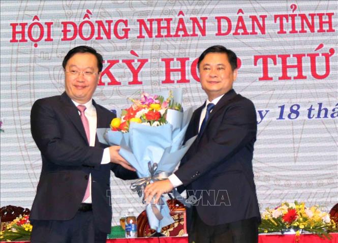 Đồng chí Thái Thanh Quý - Ủy viên dự khuyết Trung ương, Bí thư Tỉnh ủy tặng hoa chúc mừng ông Nguyễn Đức Trung. Ảnh: Tá Chuyên/TTXVN