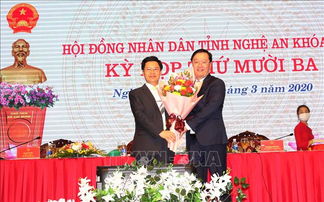 Đồng chí Nguyễn Xuân Sơn - Phó Bí thư Thường trực Tỉnh ủy, Chủ tịch Hội đồng nhân dân tỉnh Nghệ An tặng hoa chúc mừng ông Nguyễn Đức Trung. Ảnh: Tá Chuyên/TTXVN