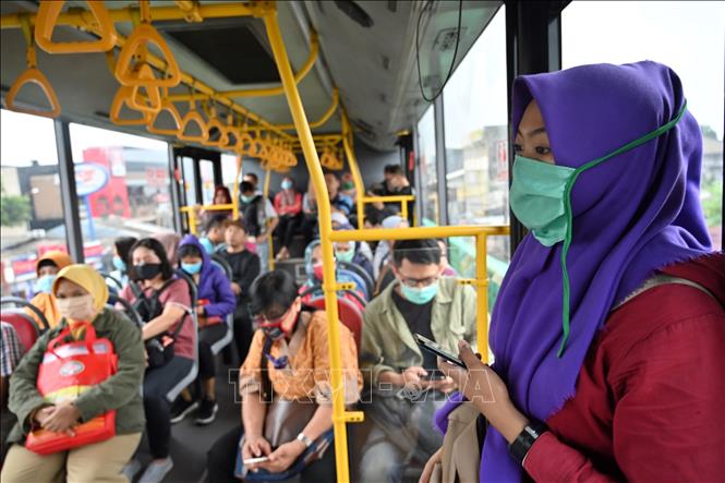 Hành khách đeo khẩu trang trên xe buýt tại Jakarta, Indonesia, ngày 18-3-2020. Ảnh: AFP/TTXVN