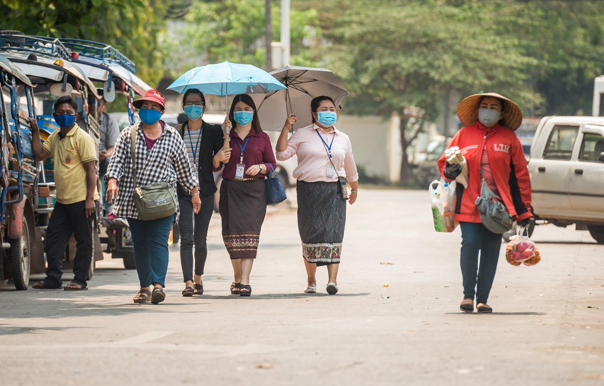 Người dân đeo khẩu trang nhằm ngăn chặn sự lây lan của dịch COVID-19 tại thủ đô Vientiane, Lào ngày 23-3-2020. Ảnh: THX/TTXVN