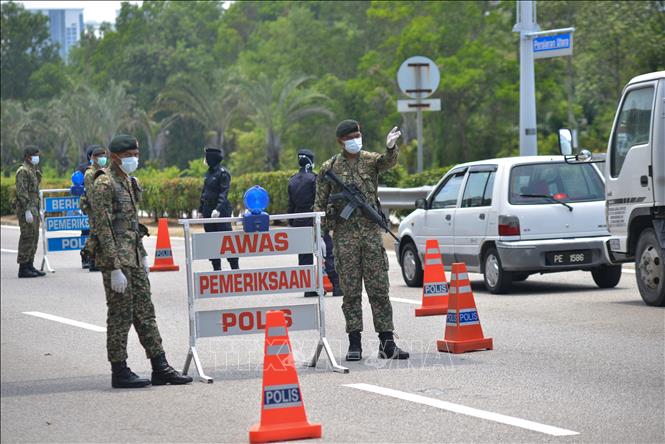 Binh sĩ Malaysia làm nhiệm vụ tại một chốt chặn trong thời gian thực thi lệnh phong tỏa nhằm ngăn dịch COVID-19 lây lan, ở Putrajaya ngày 22-3-2020. Ảnh: THX/TTXVN