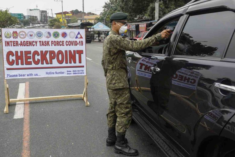 Binh sĩ Philippines đo thân nhiệt hành một lái xe tại chốt kiểm tra phòng dịch ở Quezon. Ảnh: EPA