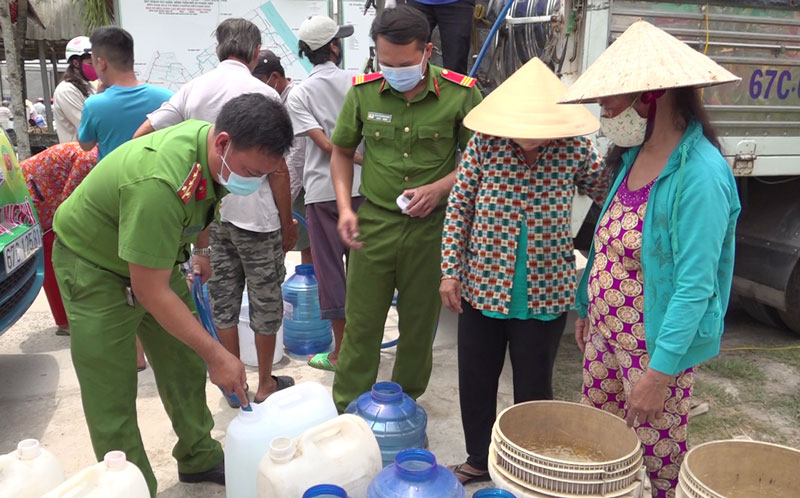 Cán bộ, chiến sĩ Công an tỉnh cung cấp nước ngọt cho người dân ở xã Phước Hiệp, huyện Mỏ Cày Nam. 