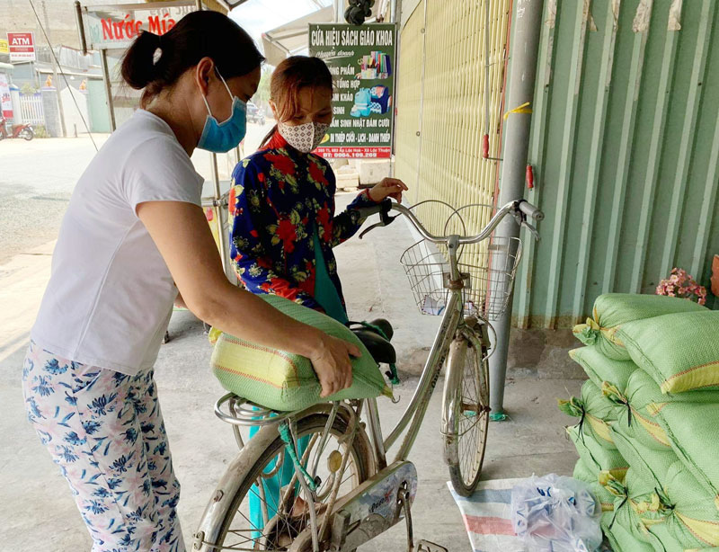 Gia đình chị Mỹ Hạnh tặng gạo cho bà con bán vé số lẻ ở xã Lộc Thuận, huyện Bình Đại. Ảnh: CTV