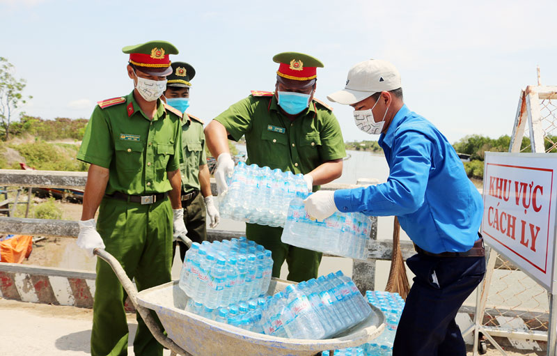 Chiến sĩ và lực lượng tình nguyện tiếp tế nước, thực phẩm cho khu cách ly ấp Thừa Lợi, xã Thừa Đức, huyện Bình Đại.  Ảnh: Phan Hân