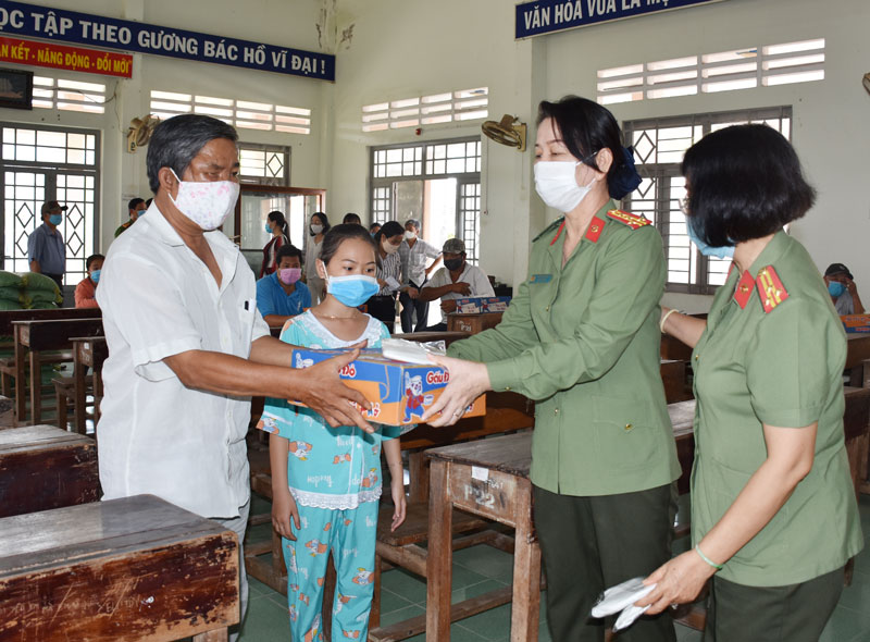 Đại tá Trần Thị Bé Nhân - Phó giám đốc Công an tỉnh tặng quà cho hộ nghèo tại xã An Thạnh. Ảnh: Thảo Giang.