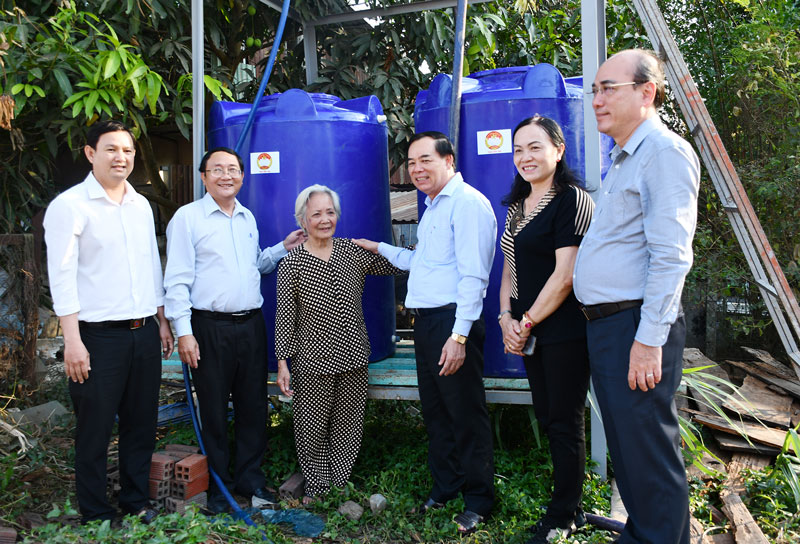 Phó bí thư Thường trực Tỉnh ủy Trần Ngọc Tam (thứ 3, phải sang) thăm hỏi bà Nguyễn Thị Hưởn đã tích cực hỗ trợ nước ngọt tại xã Phú Hưng (TP. Bến Tre). Ảnh: Hữu Hiệp