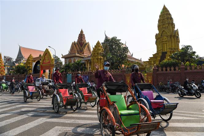 Người dân đeo khẩu trang phòng lây nhiễm COVID-19 trên một đường phố ở Phnom Penh, Campuchia, ngày 30-3-2020. Ảnh: AFP/TTXVN