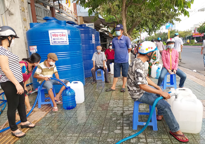 Người dân xếp hàng trật tự chờ lấy nước ngọt miễn phí tại một điểm cấp nước ở phường Phú Khương, TP. Bến Tre.