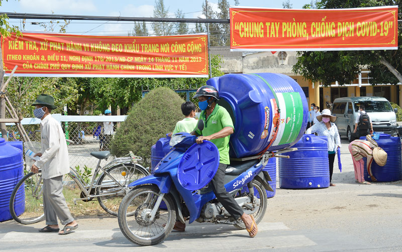 Người dân xã An Ngãi Tây (Ba Tri) nhận bồn chứa nước do Hội Doanh nhân trẻ Bến Tre trao tặng. Ảnh: Ánh Nguyệt