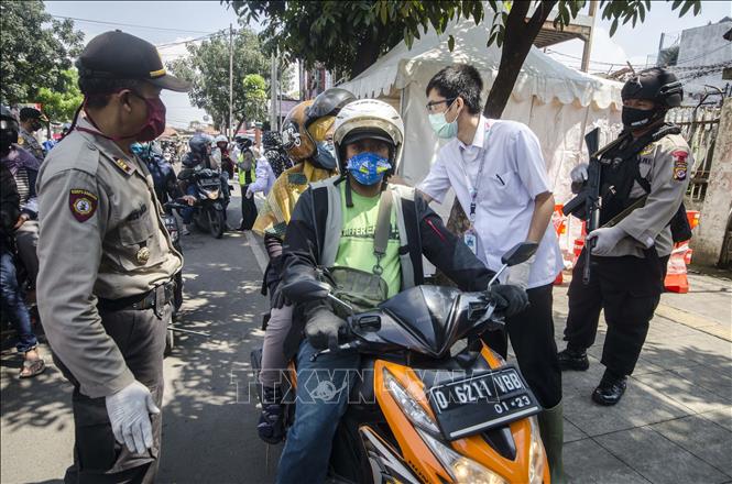 Cảnh sát kiểm tra các phương tiện tại một chốt kiểm soát phòng dịch COVID-19 ở Bandung, Indonesia, ngày 22-4-2020. Ảnh: THX/TTXVN