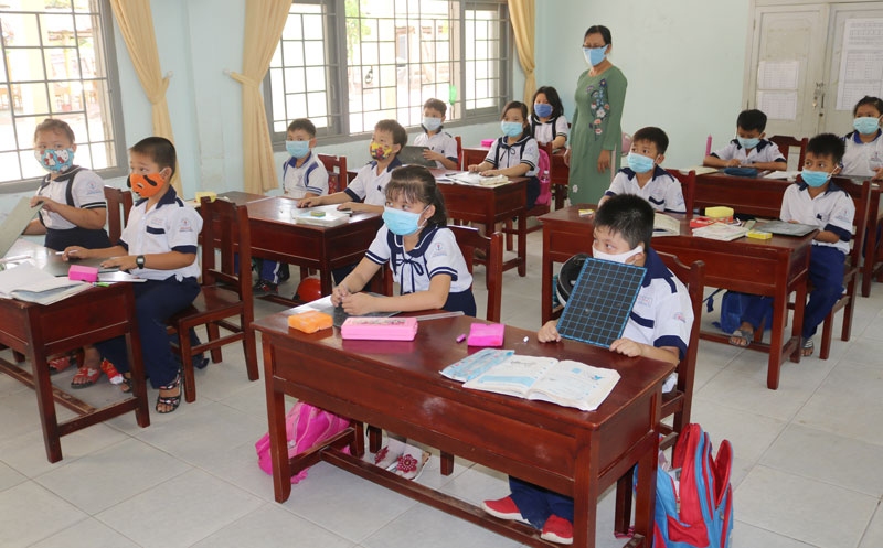 Học sinh trường Tiểu học Bình Thành thực hiện ngồi giãn cách để phòng chống dịch 