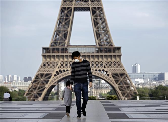  Trẻ em thăm Tháp Eiffel ở Paris, Pháp trong bối cảnh dịch COVID-19 bùng phát mạnh, ngày 20-4-2020. Ảnh: AFP/TTXVN