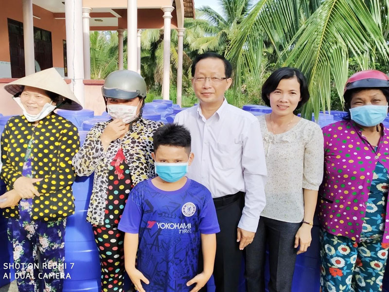 Phó chủ tịch UBND tỉnh Nguyễn Trúc Sơn trao bồn chứa nước ngọt cho người dân.