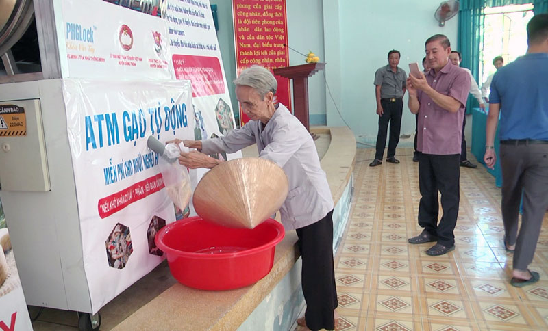 Người dân nhận gạo từ máy ATM.