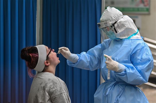  Nhân viên y tế lấy mẫu xét nghiệm COVID-19 cho người dân tại Vũ Hán, Trung Quốc ngày 14-5-2020. Ảnh: AFP/TTXVN