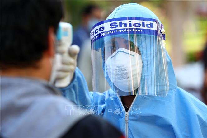Nhân viên y tế kiểm tra thân nhiệt người dân nhằm ngăn chặn sự lây lan của dịch COVID-19 tại Giza, Ai Cập ngày 10-5-2020. Ảnh: THX/TTXVN