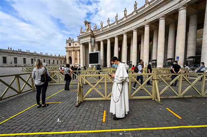  Du khách xếp hàng chờ kiểm tra thân nhiệt trước khi vào Nhà thờ Thánh Peter tại Tòa thánh Vatican ngày 18-5-2020. Ảnh: AFP/TTXVN