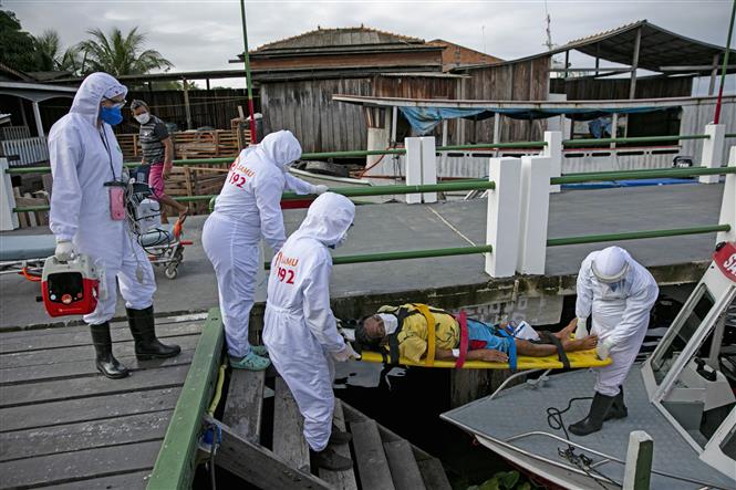  Nhân viên y tế chuyển bệnh nhân nhiễm COVID-19 tới bệnh viện ở Breves, trên đảo Marajo, Brazil. Ảnh: AFP/TTXVN