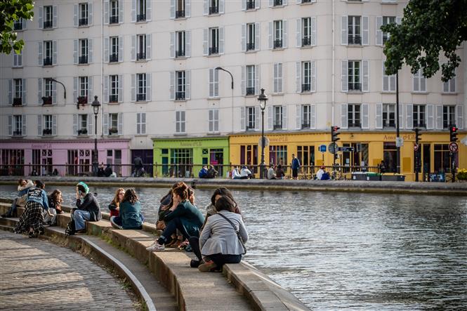 Người dân thư giãn bên sông Saint-Martin ở Paris, Pháp khi lệnh phong tỏa được nới lỏng, ngày 13-5-2020. Ảnh: THX/TTXVN