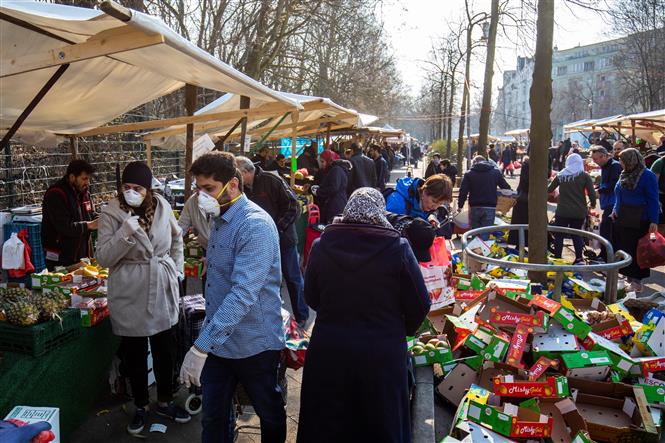  Người dân mua sắm tại một khu chợ ở Berlin, Đức ngày 28-3-2020. Ảnh: AFP/TTXVN