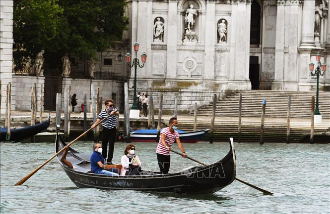 Người dân đi thuyền gondola tại thành Venice, Italy ngày 30-5-2020 khi lệnh hạn chế được nới lỏng. Ảnh: AFP/TTXVN