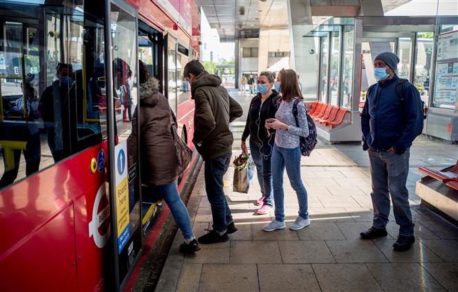 Hành khách đeo khẩu trang phòng dịch COVID-19 khi đi xe buýt tại London, Anh ngày 18-5-2020. Ảnh: AFP/TTXVN