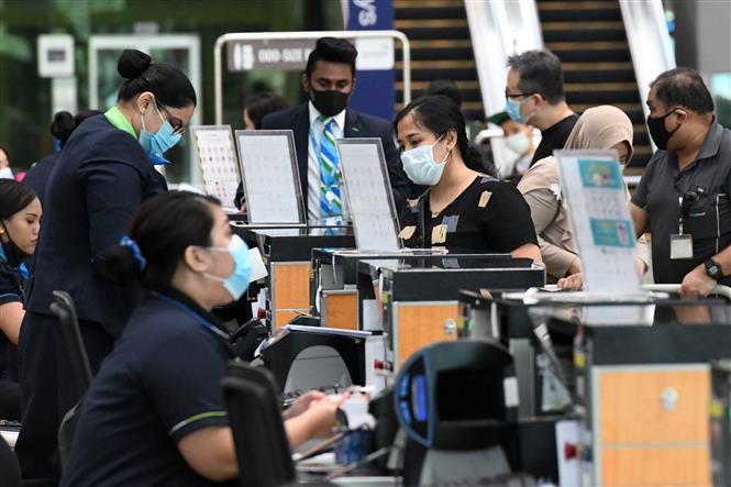 Hành khách làm thủ tục tại sân bay quốc tế Changi ở Singapore ngày 8-6-2020. Ảnh: AFP/TTXVN