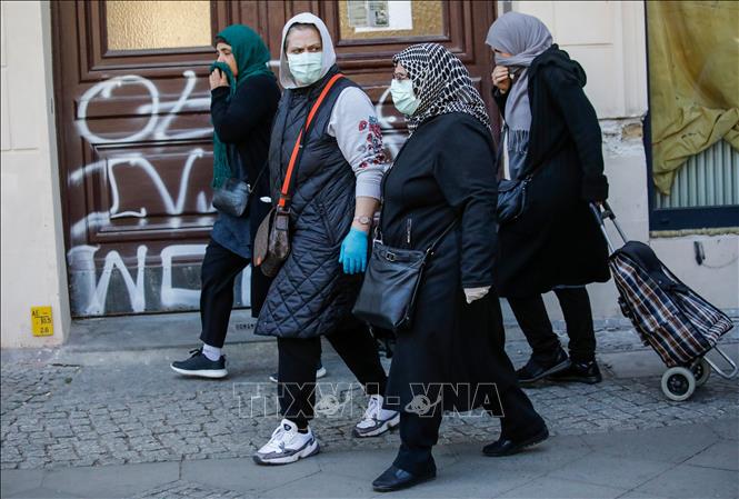 Người dân đeo khẩu trang phòng dịch COVID-19 tại Berlin, Đức ngày 17-4-2020. Ảnh: AFP/TTXVN