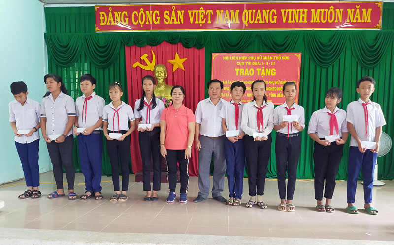 Các em học sinh nhận quà từ nhà tài trợ. Ảnh: Phan Thảo