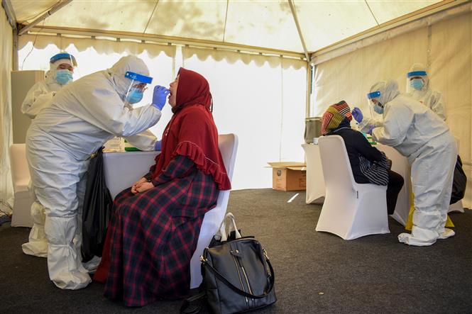 Nhân viên y tế lấy mẫu dịch xét nghiệm COVID-19 cho người dân tại Bandung, Indonesia, ngày 11-7-2020. Ảnh: AFP/ TTXVN