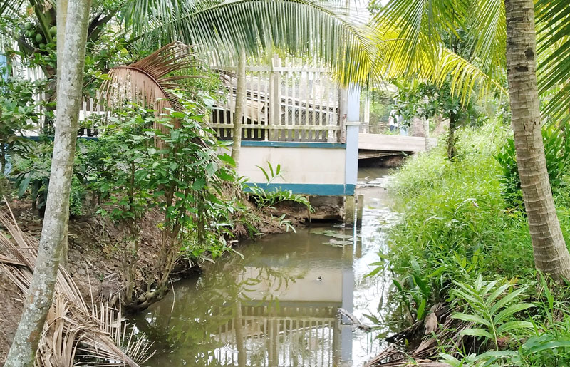 Tường rào nhà bà Quyên xây lấn ra hơn nửa mương dẫn nước cầu Búng. Ảnh: Trần Ba