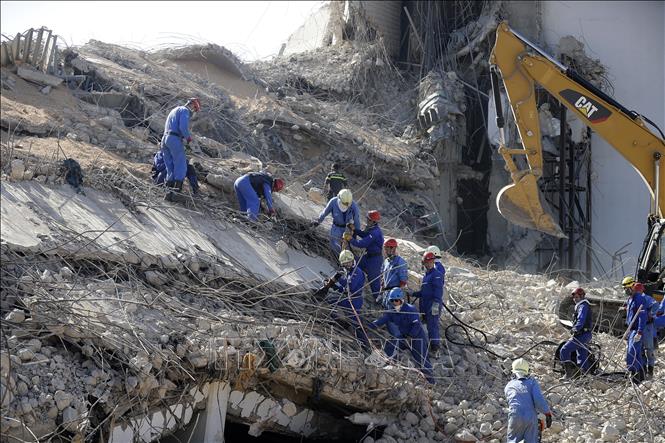 Nhân viên cứu hộ tìm kiếm nạn nhân dưới đống đổ nát sau vụ nổ ở cảng Beirut, Liban, ngày 7-8-2020. Ảnh: AFP/TTXVN
