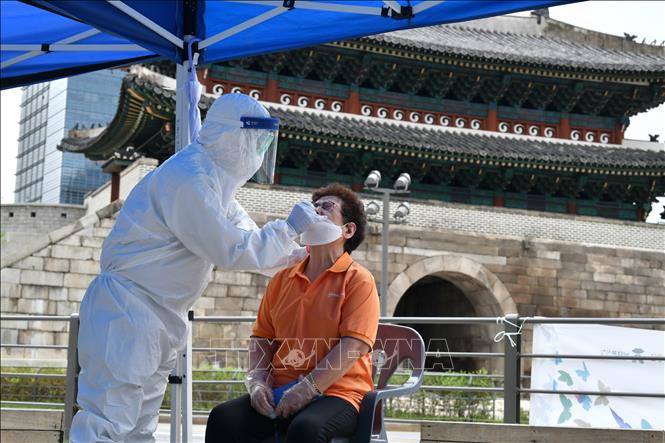 Nhân viên y tế lấy mẫu xét nghiệm COVID-19 cho người dân tại Seoul, Hàn Quốc ngày 10-8. Ảnh: AFP/TTXVN