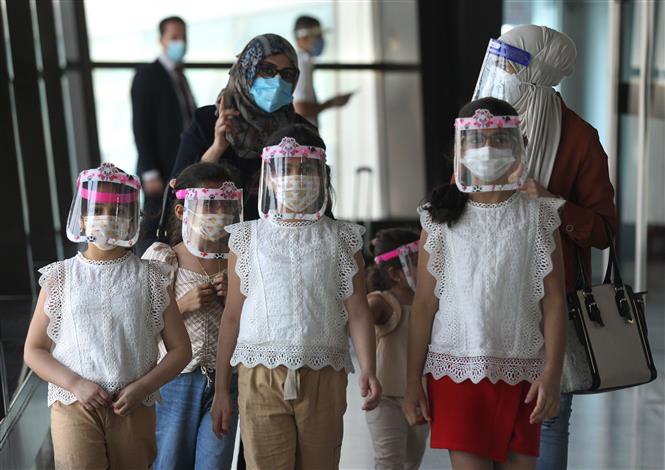 Một gia đình đeo khẩu trang phòng lây nhiễm COVID-19 tại sân bay ở Baghdad, Iraq. Ảnh: AFP/TTXVN
