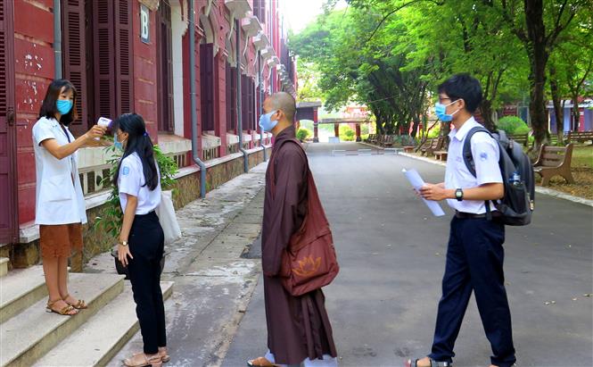 Trên 26.000 thí sinh thi tốt nghiệp THPT đợt 2 bắt đầu làm bài thi Ngữ văn Lực lượng y tế đo thân nhiệt cho các thí sinh trước khi vào phòng thi của tỉnh Thừa Thiên - Huế. Ảnh: Tường Vi /TTXVN
