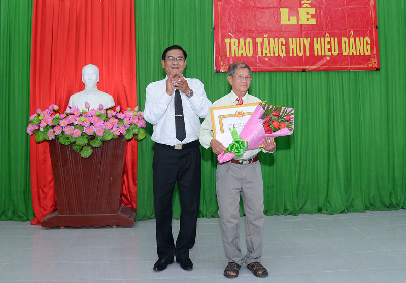 Chủ nhiệm Ủy ban Kiểm tra Tỉnh ủy Nguyễn Hải Châu trao tặng Huy hiệu Đảng.