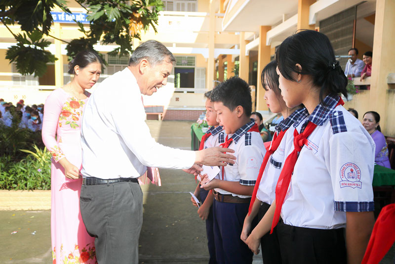 Chủ tịch UBND tỉnh Cao Văn Trọng trao học bổng cho các em học sinh. Ảnh: Phan Hân