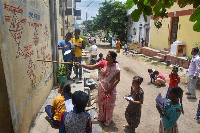 Giáo viên giảng bài cho học sinh tại một lớp học ngoài trời ở Solapur, bang Maharashtra, Ấn Độ, ngày 27-8-2020. Ảnh: AFP/ TTXVN