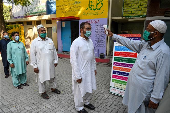 Kiểm tra thân nhiệt phòng lây nhiễm COVID-19 tại Lahore, Pakistan, ngày 12-9-2020. Ảnh: AFP/TTXVN