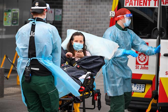 Nhân viên y tế chuyển bệnh nhân mắc COVID-19 lên xe cứu thương tại bang Victoria, Australia ngày 28-7-2020. Ảnh: AFP/TTXVN